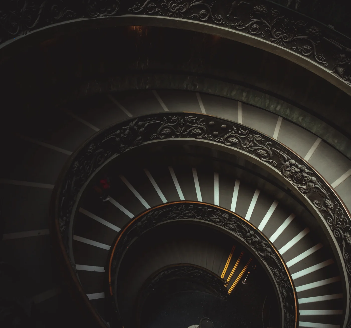Looking down a sculpted spiral staircase with ornate balustrades, the image Puravankara uses for The Art of Development since 1975
