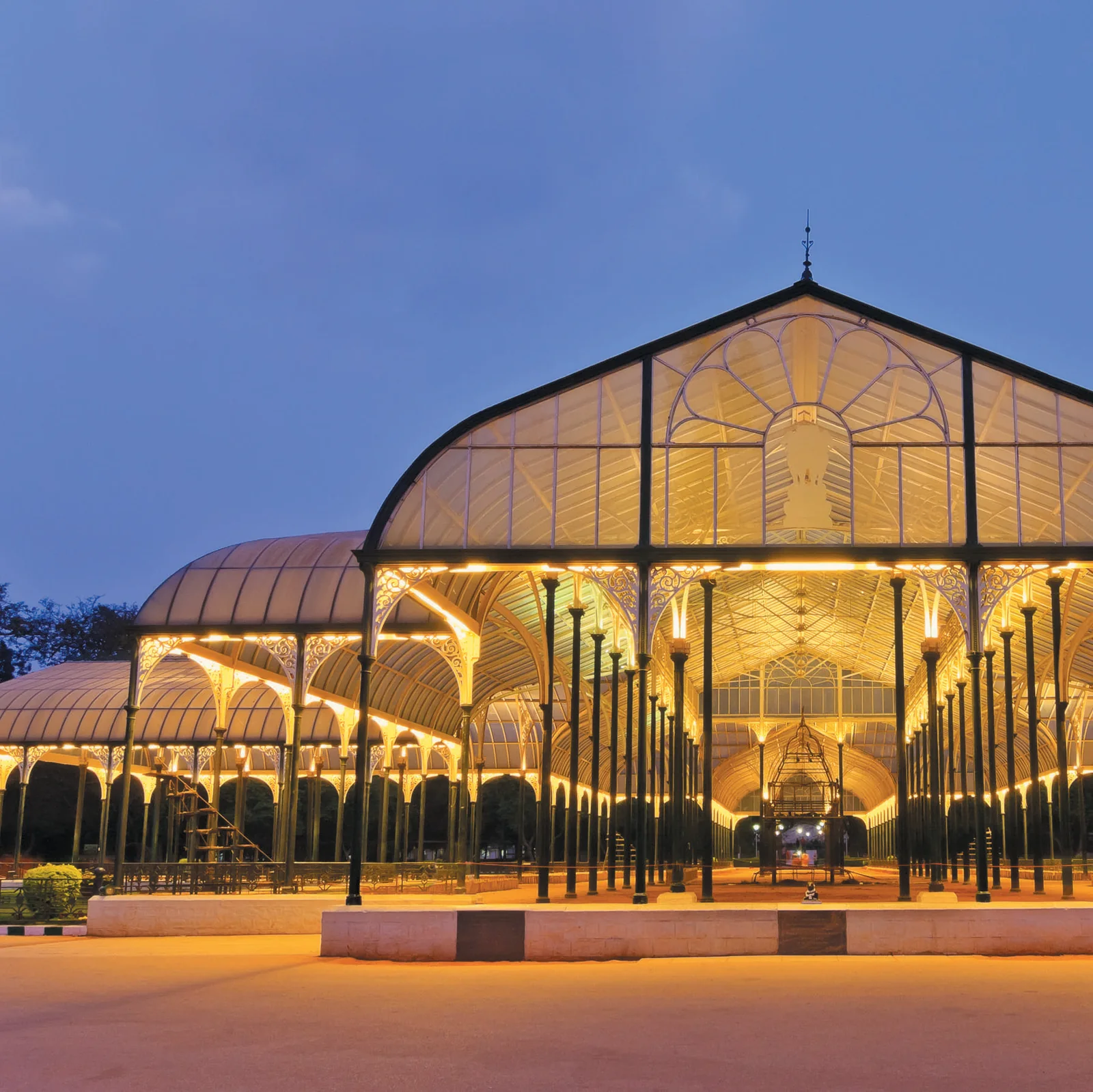 The Victorian glass house at Lalbagh Botanical Garden lit at dusk, about five minutes from Purva Orient Grand