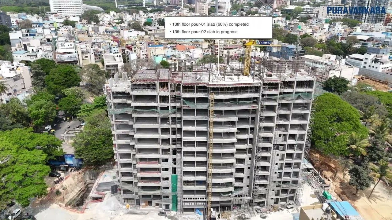 Earlier Purva Orient Grand construction photograph with Puravankara's callouts reading 13th floor pour-01 slab 60% completed and 13th floor pour-02 slab in progress
